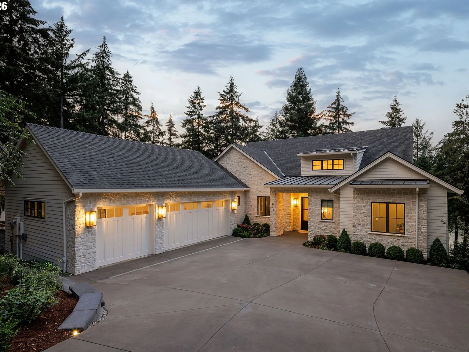 The front facade of 843 Terrace Dr at dusk, stone veneer and warm sconce lighting