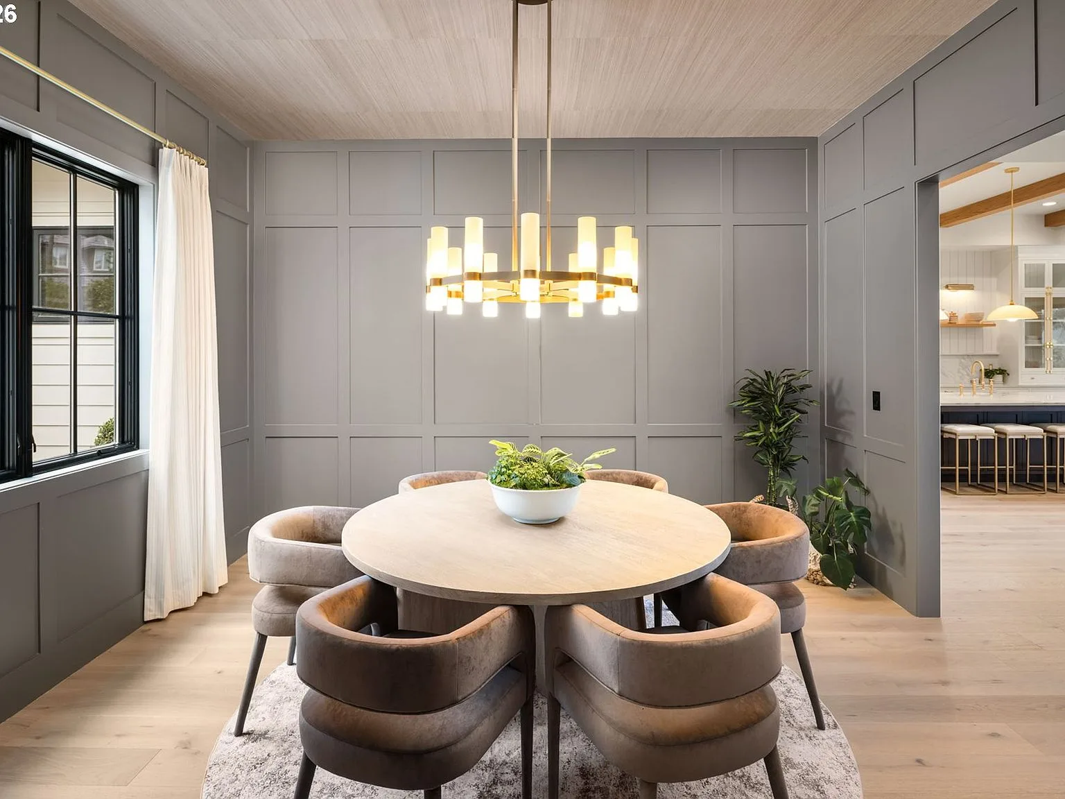 Dining room with floor-to-ceiling wainscoting, round table, and chandelier