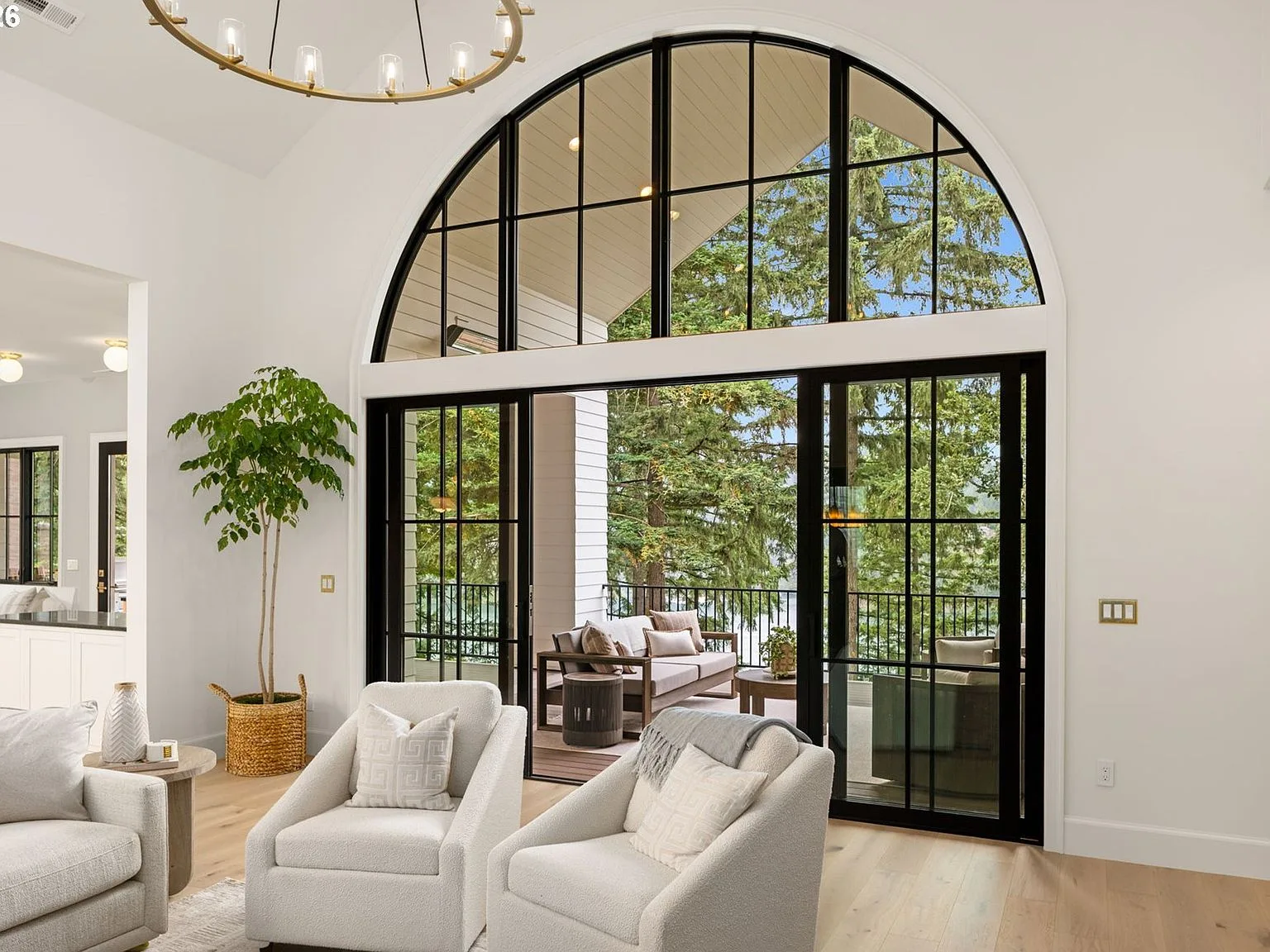 Living room with floor-to-ceiling arched glass doors overlooking the lake