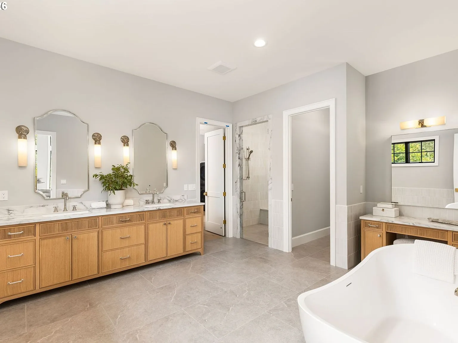 The spa-inspired primary bath with marble countertops and a freestanding soaking tub