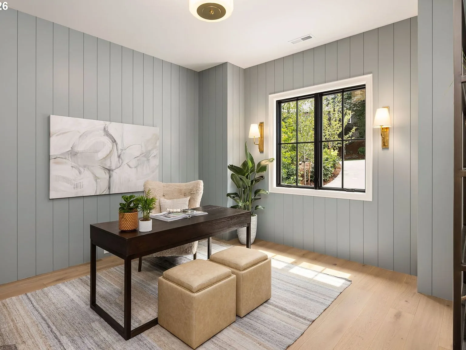 Home office with light blue paneled walls and natural daylight