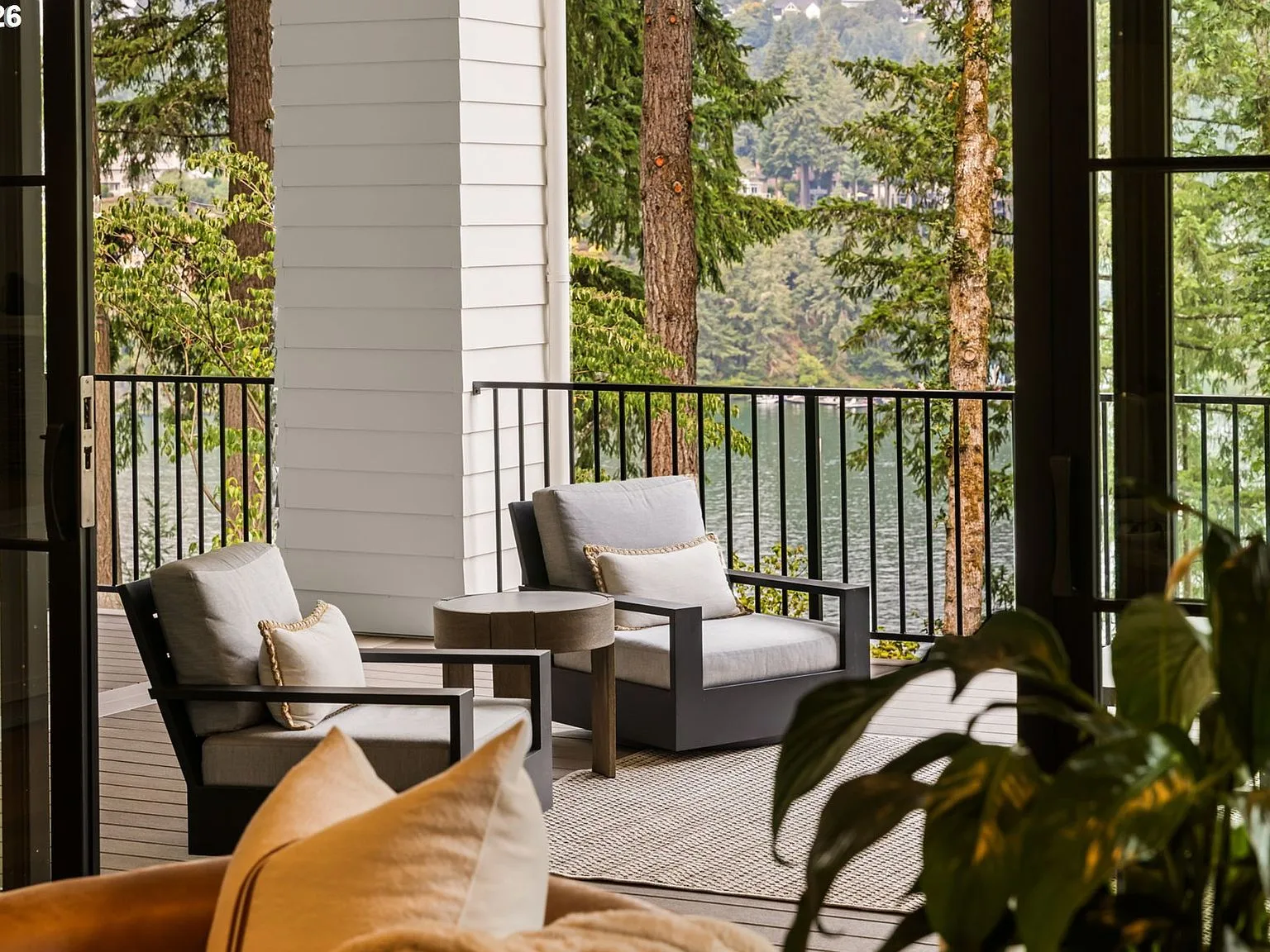 View from interior looking out to a covered terrace with lake views