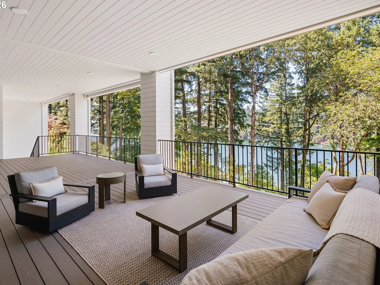 Covered outdoor terrace overlooking the lake with lounge seating