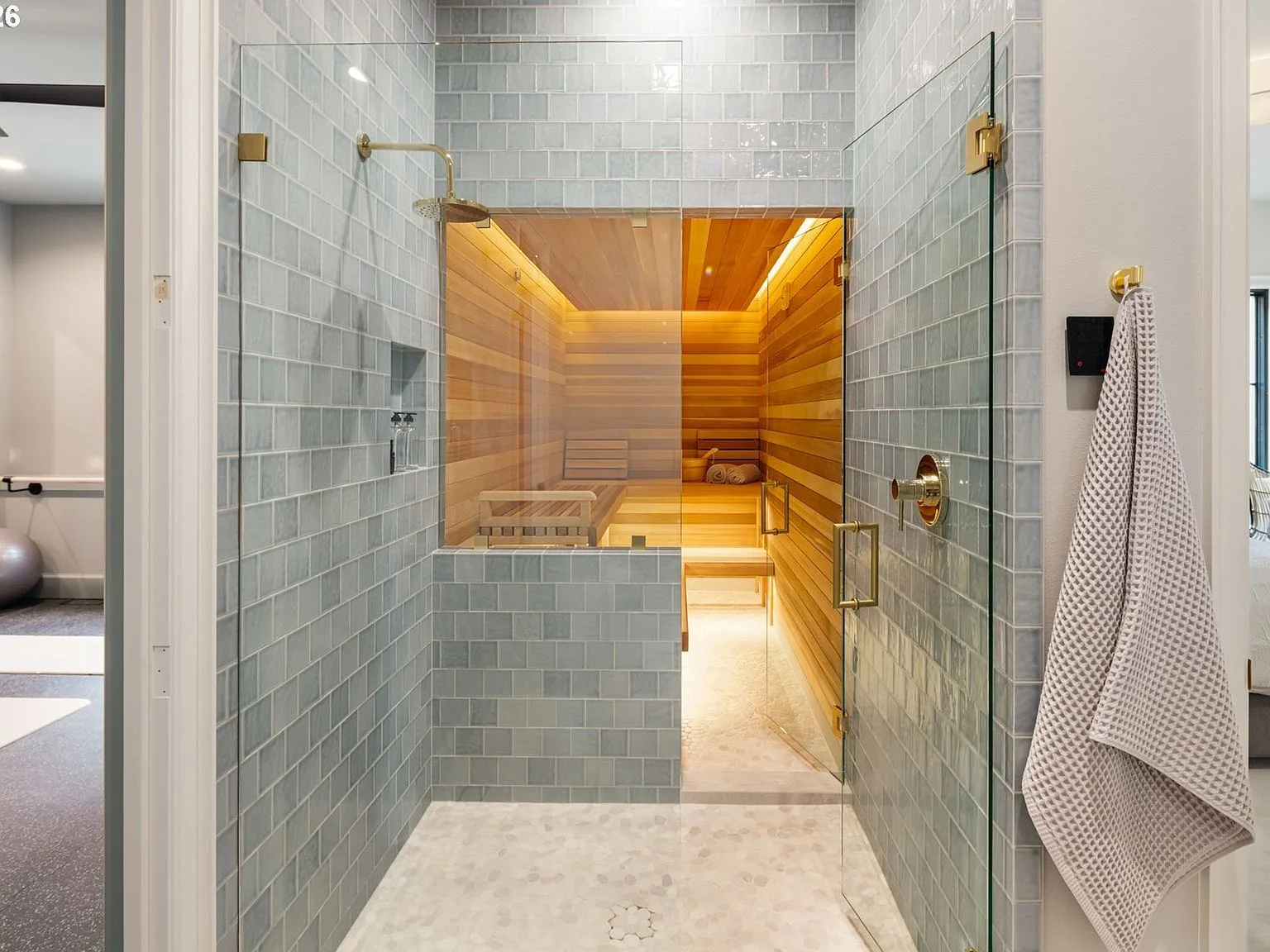 Cedar-lined sauna and glass-enclosed shower with light blue subway tile