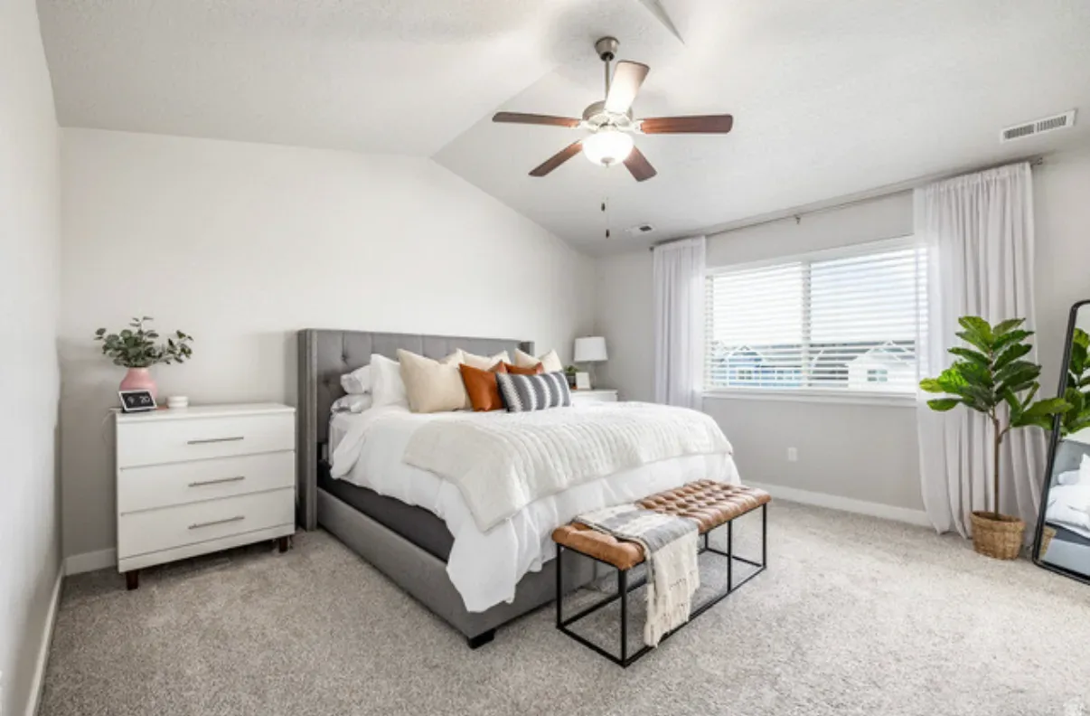 Master bedroom with vaulted ceilings and large windows