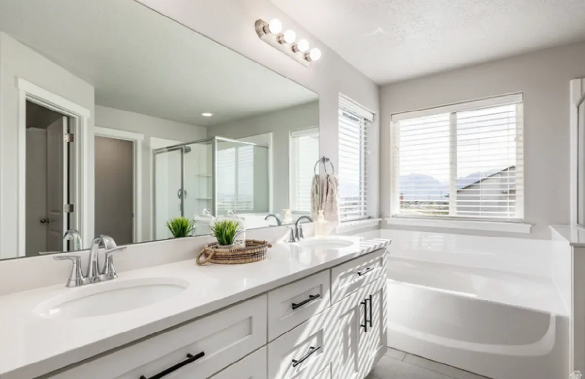 Master bathroom vanity with white cabinetry, large mirror, and tile flooring
