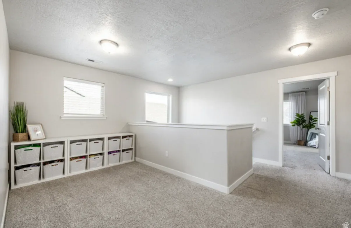 Upstairs landing loft area with storage and view into adjacent bedroom