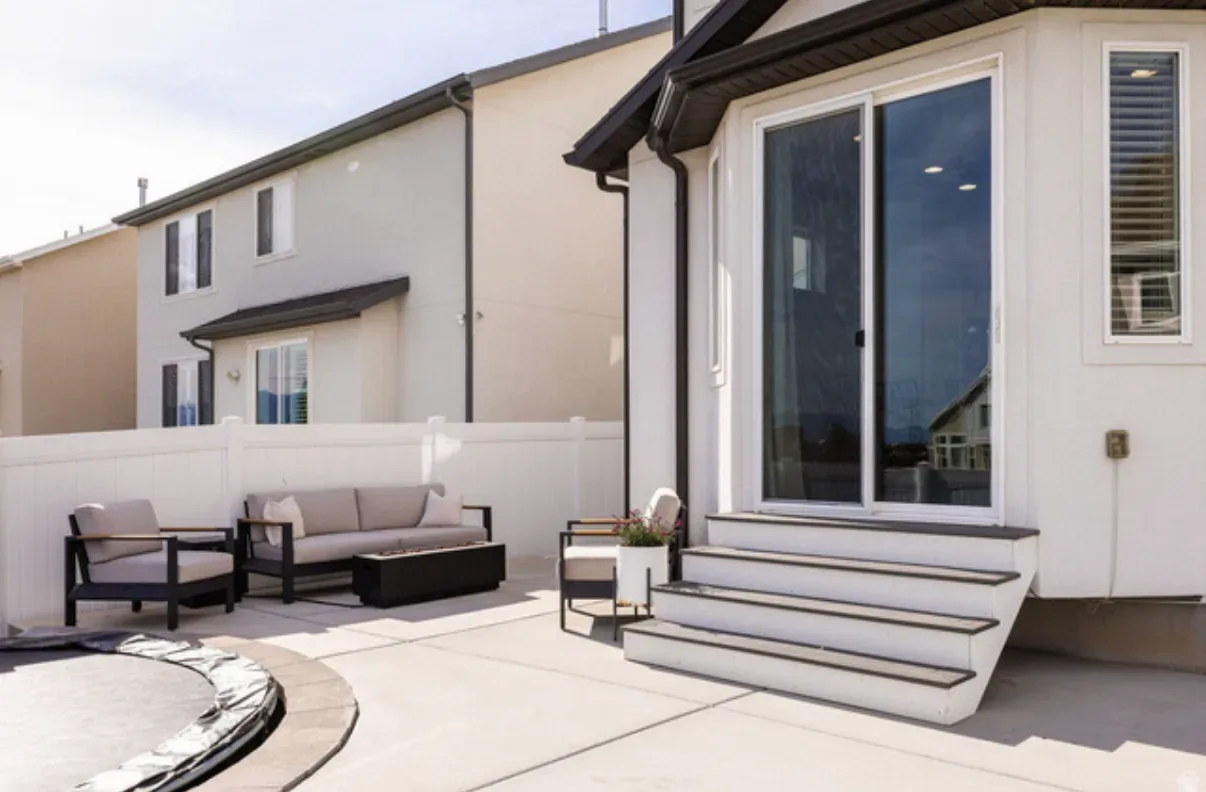 Backyard patio with outdoor sofa, chairs, and sliding glass door access