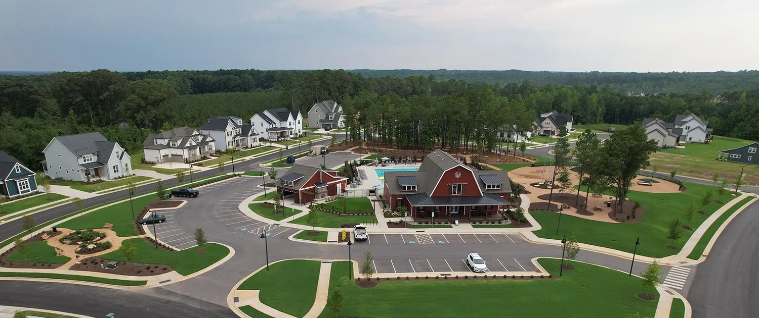 Aerial view of a neighborhood amenity center with a clubhouse and pool near The Hills at Southpoint