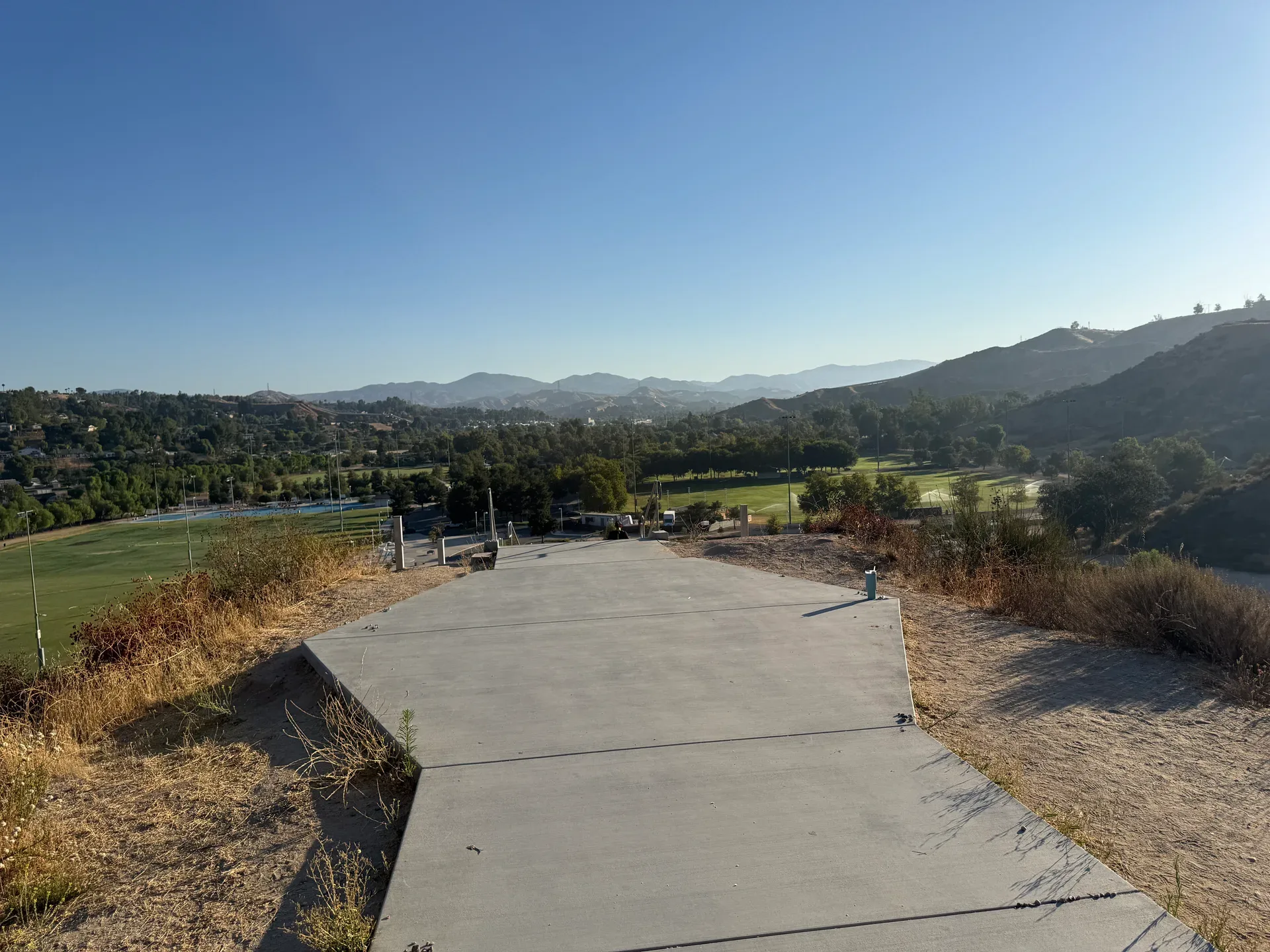 Panoramic view of Santa Clarita Valley from the top of the SCV Stairs with rolling hills and a clear blue sky