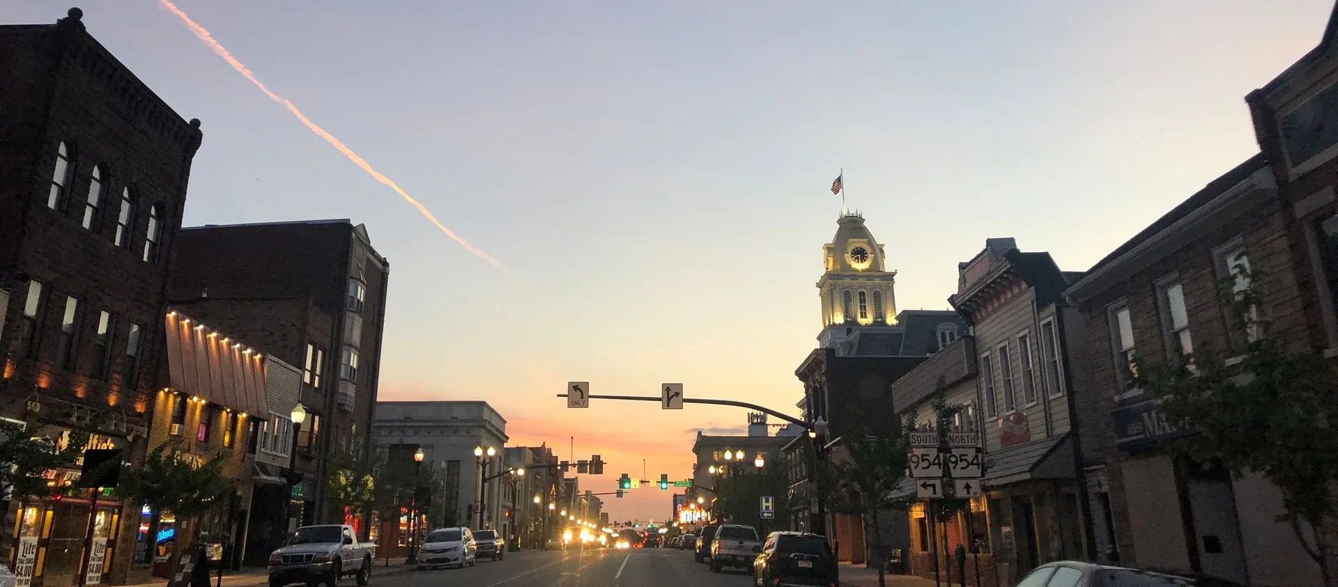 Downtown Indiana, PA street at sunset with the historic clock tower glowing in the warm light