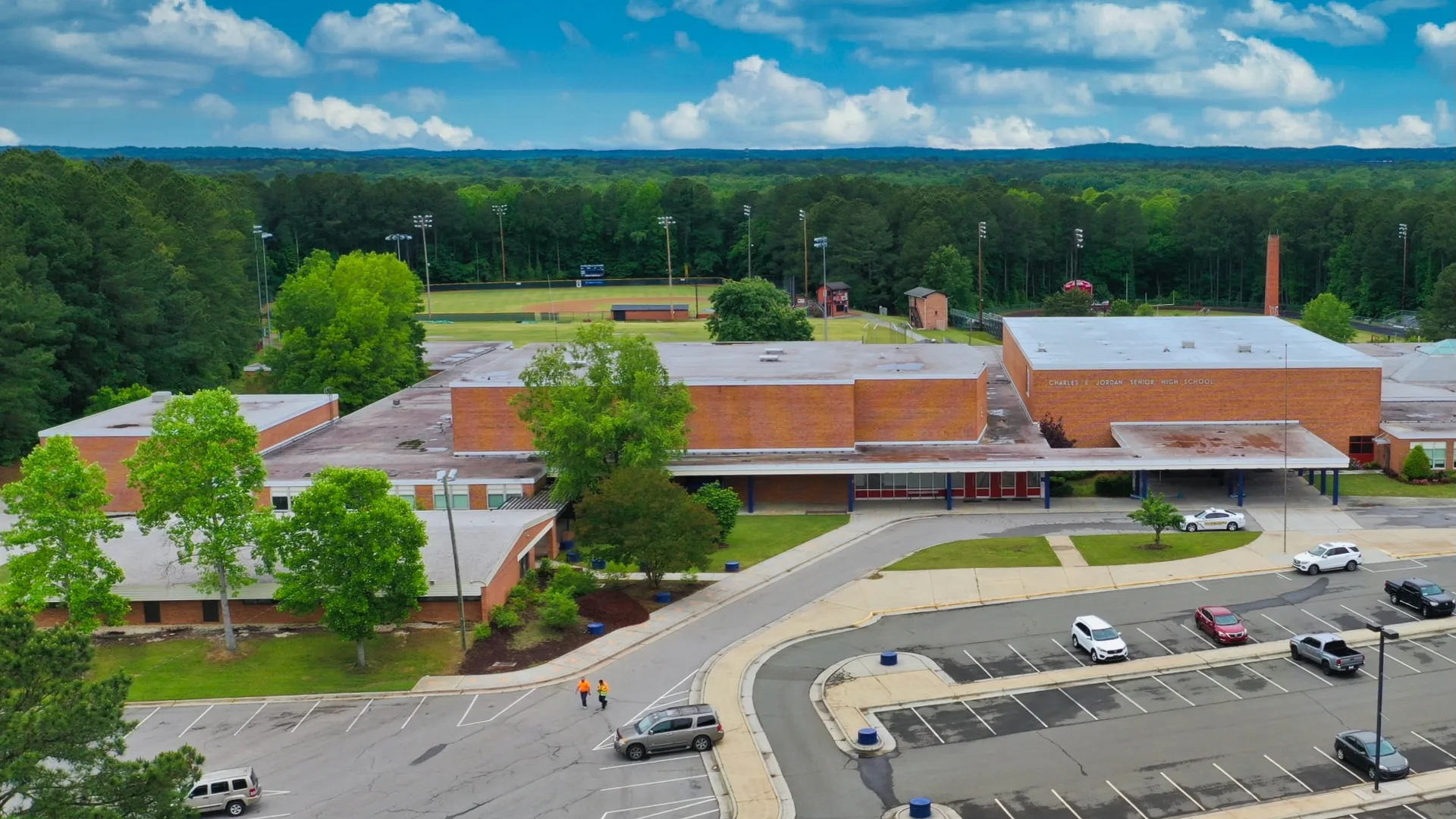 Aerial view of a school campus with brick buildings and athletic fields serving the Forest Hills area