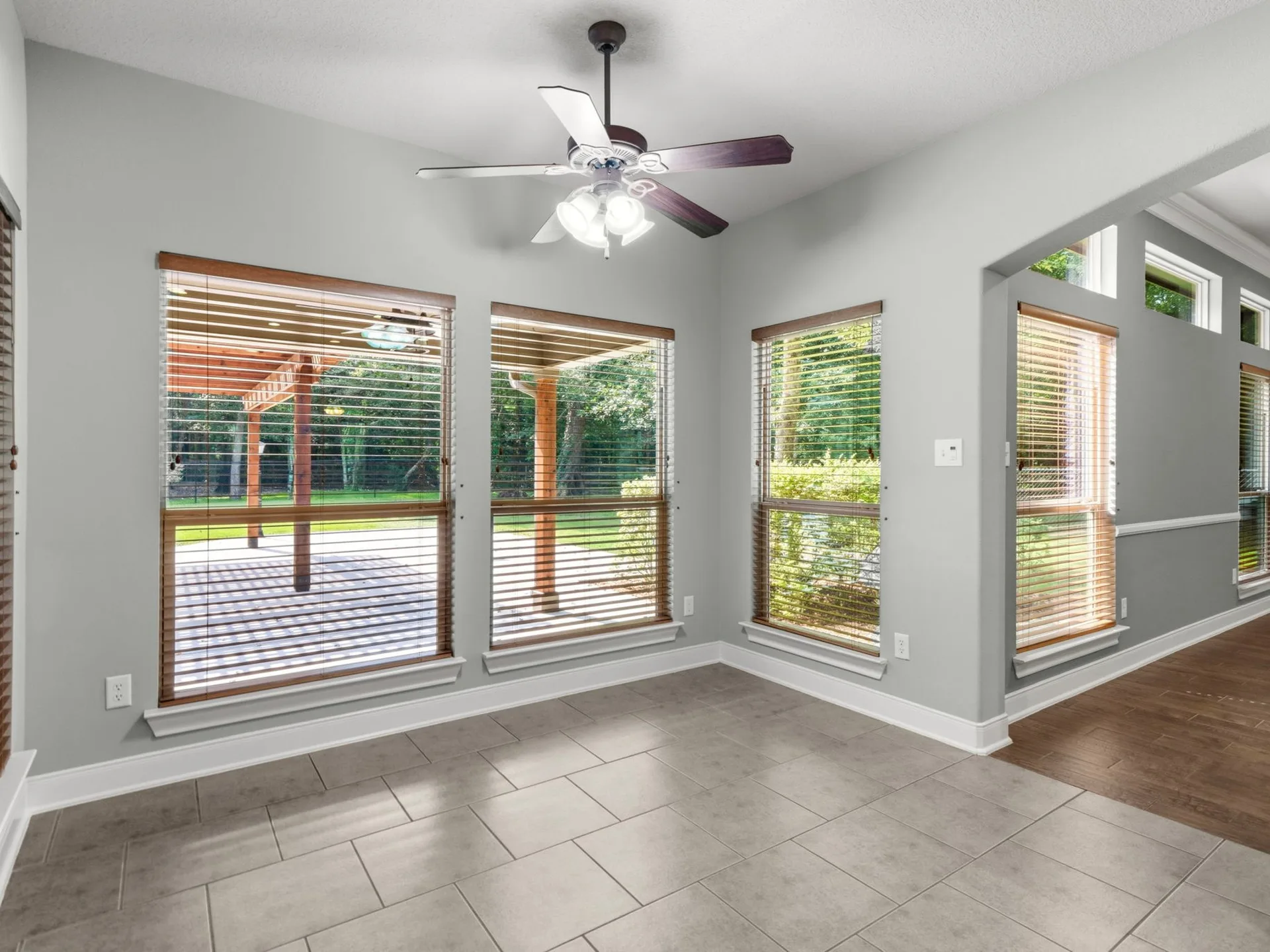 Sun room or breakfast area with large windows and tiled flooring overlooking the backyard patio