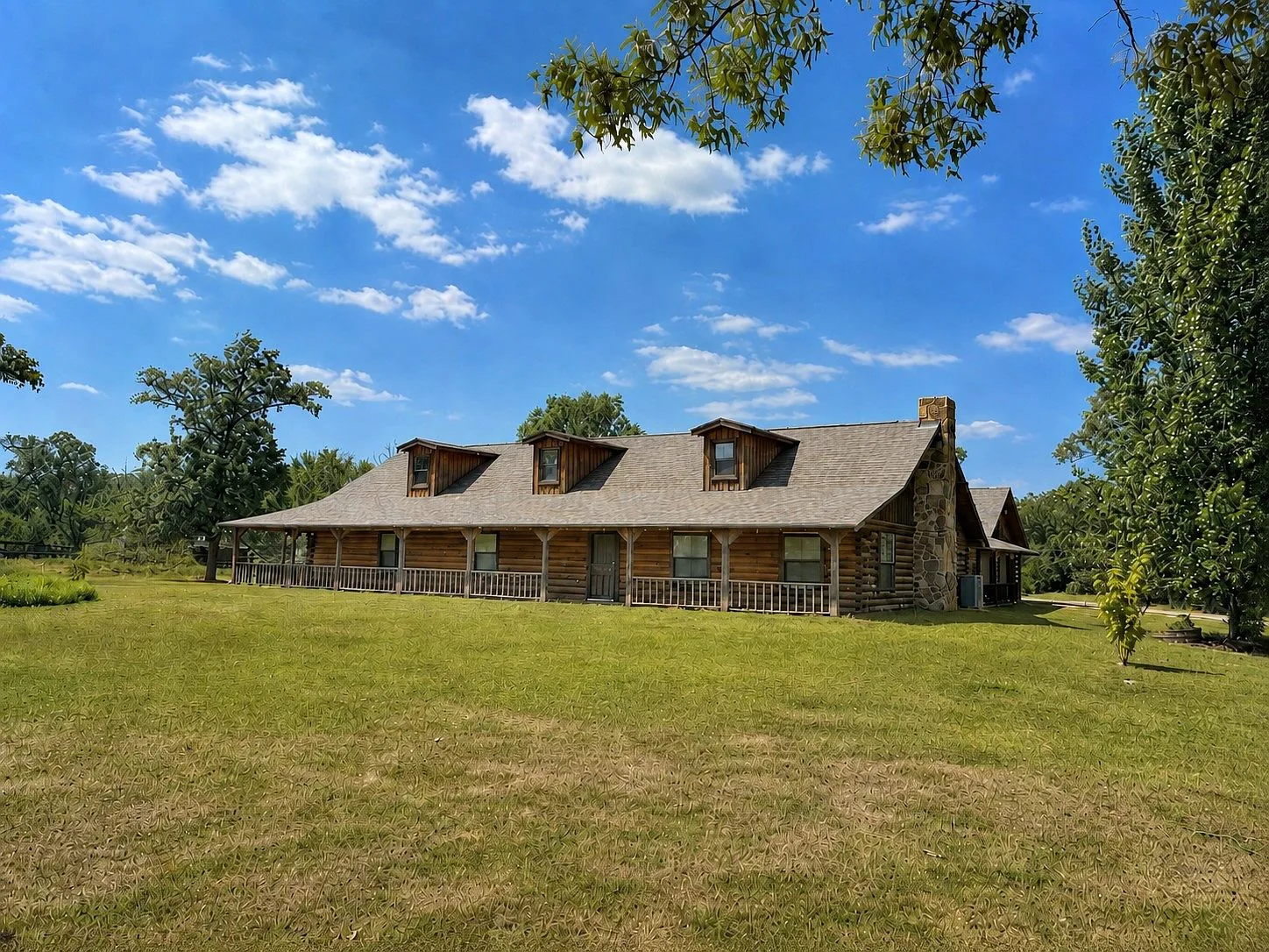 Front facade of the rustic log cabin with wrap-around porch