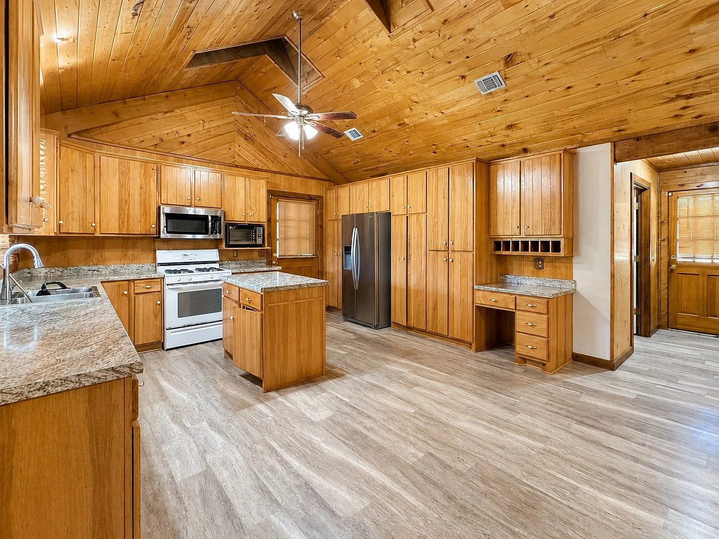 Log cabin kitchen with wood walls and stone countertops