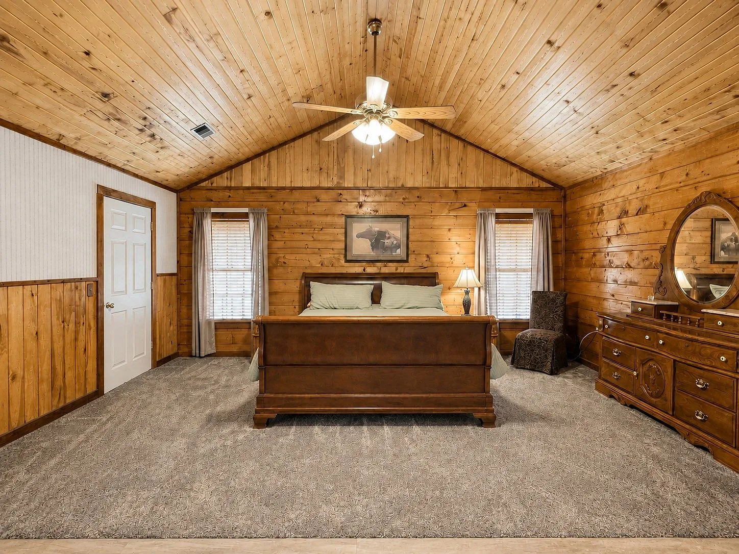 Master bedroom with vaulted wood ceiling and natural light