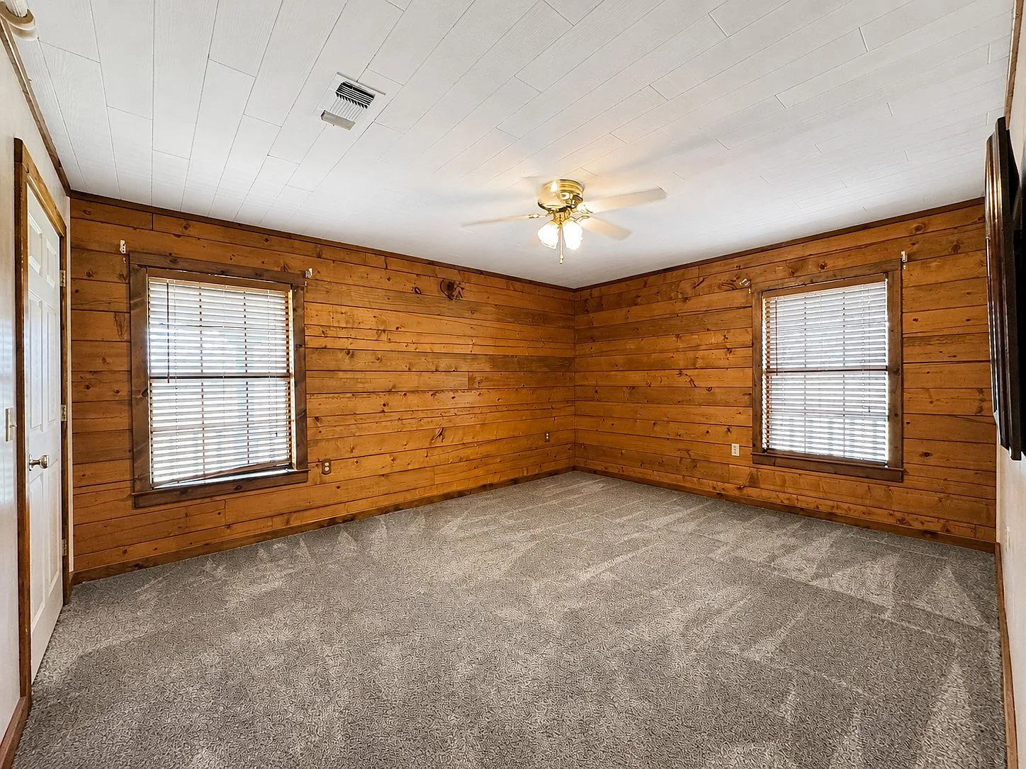Bedroom with wood walls and white ceiling