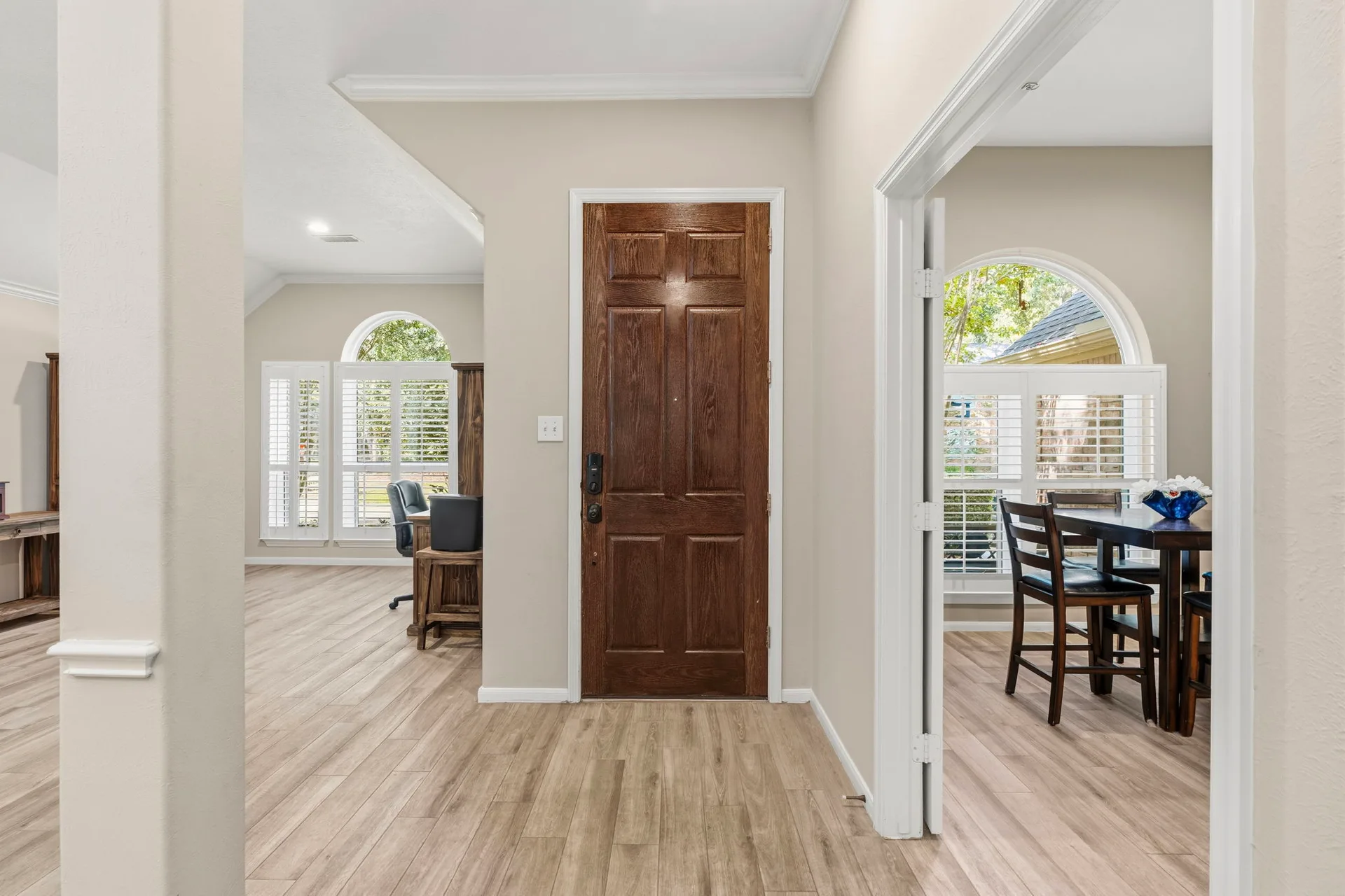 Hallway view looking toward the front door with wood-look tile flooring