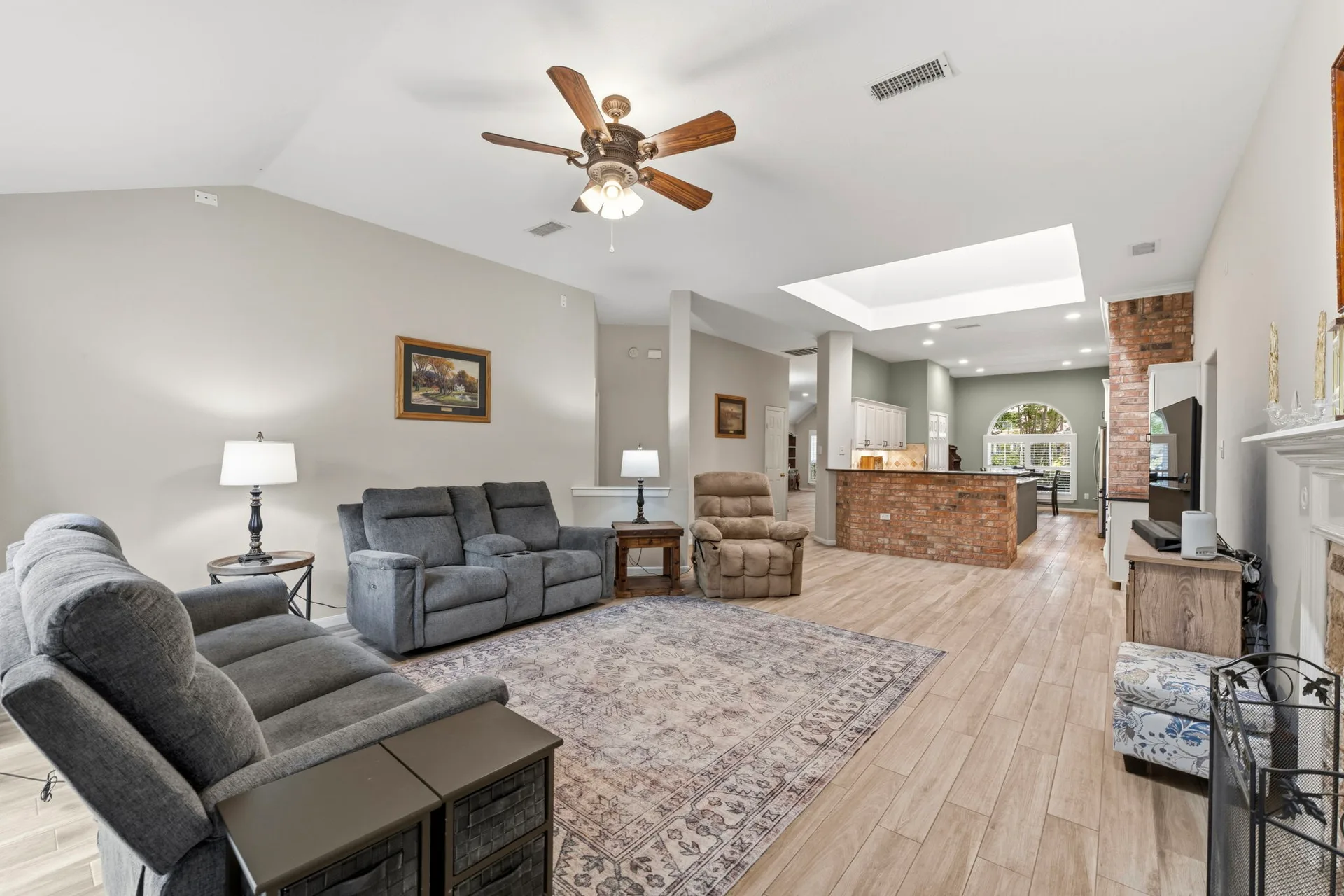 Open living area and kitchen with brick accent