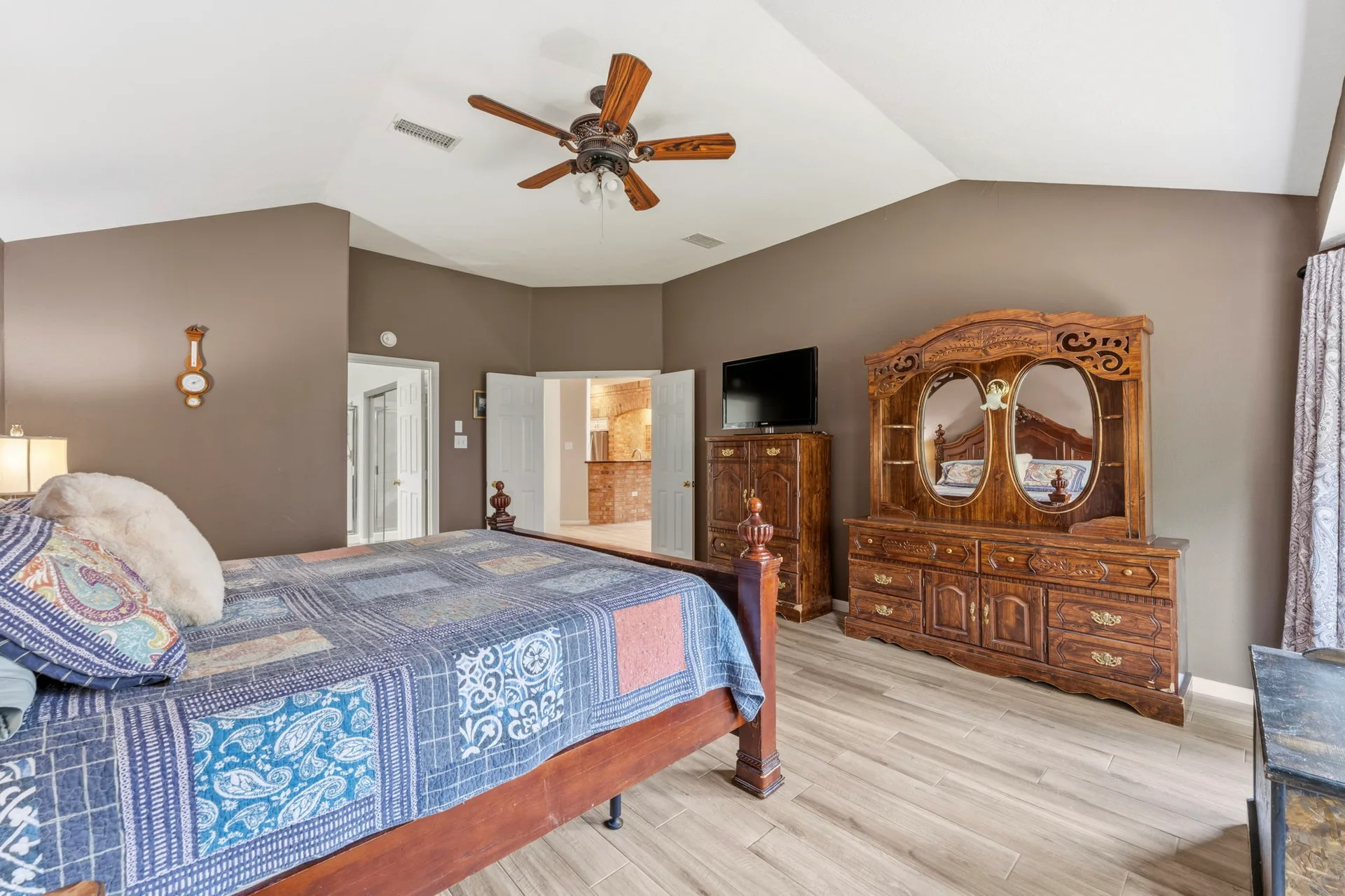Primary bedroom with vaulted ceilings and walkthrough to bath area