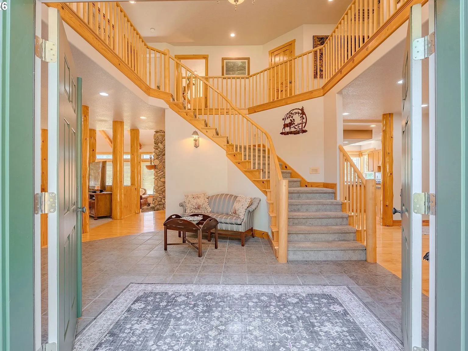 Foyer with slate tile and natural wood railings, seen from the front door