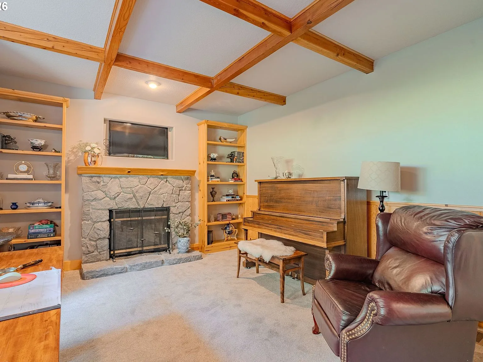 Living room with river rock fireplace and exposed wood ceiling beams