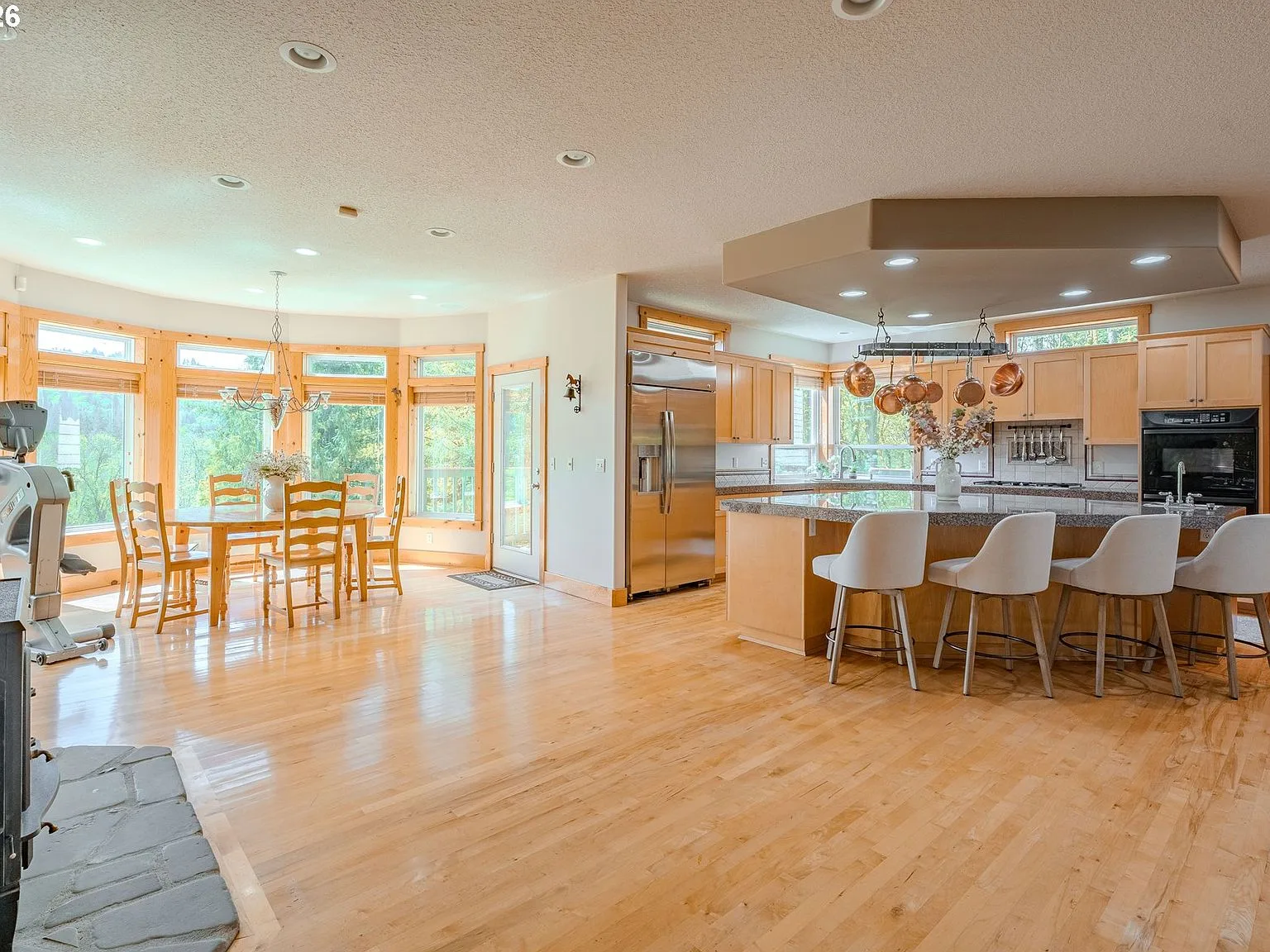 Kitchen and dining area with light wood cabinetry and hardwood flooring