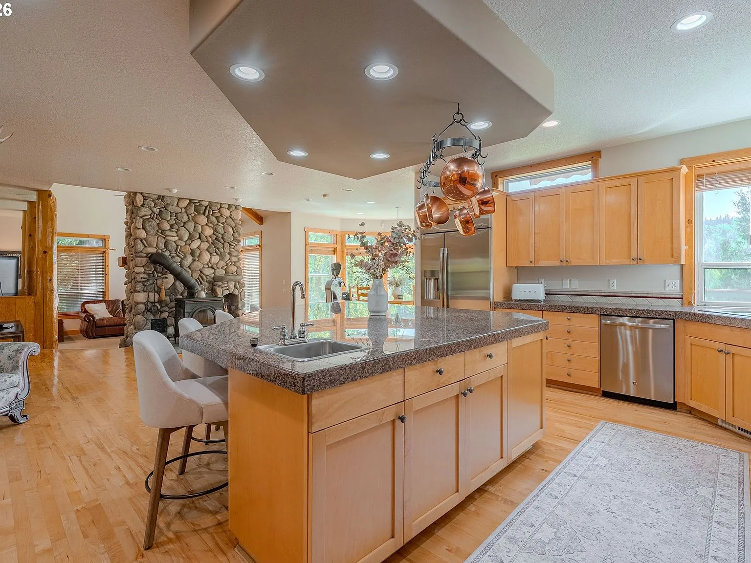 Kitchen with 8 by 8 foot island, river-rock hearth, and natural wood cabinetry