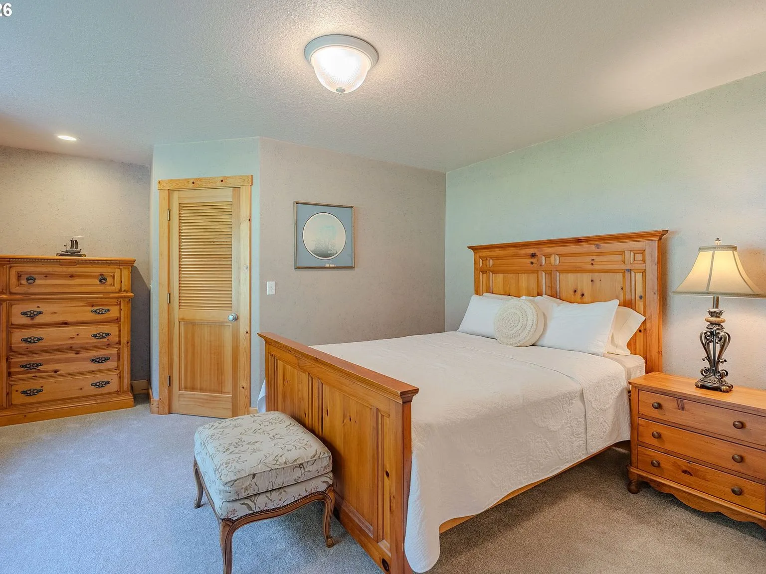 Secondary bedroom with wood furniture and beige walls