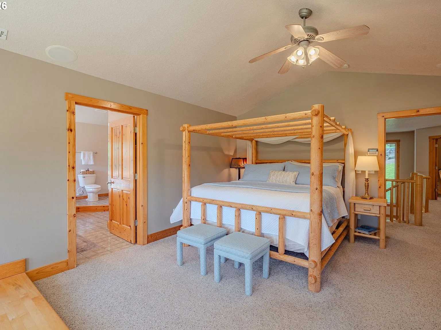 Primary bedroom with four-poster log bed and vaulted ceiling