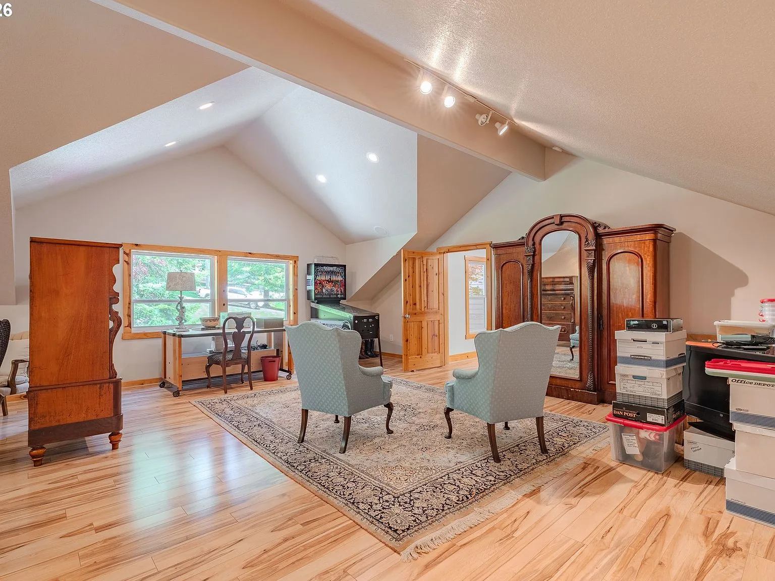 Large bonus room with vaulted ceilings, wood flooring, and track lighting