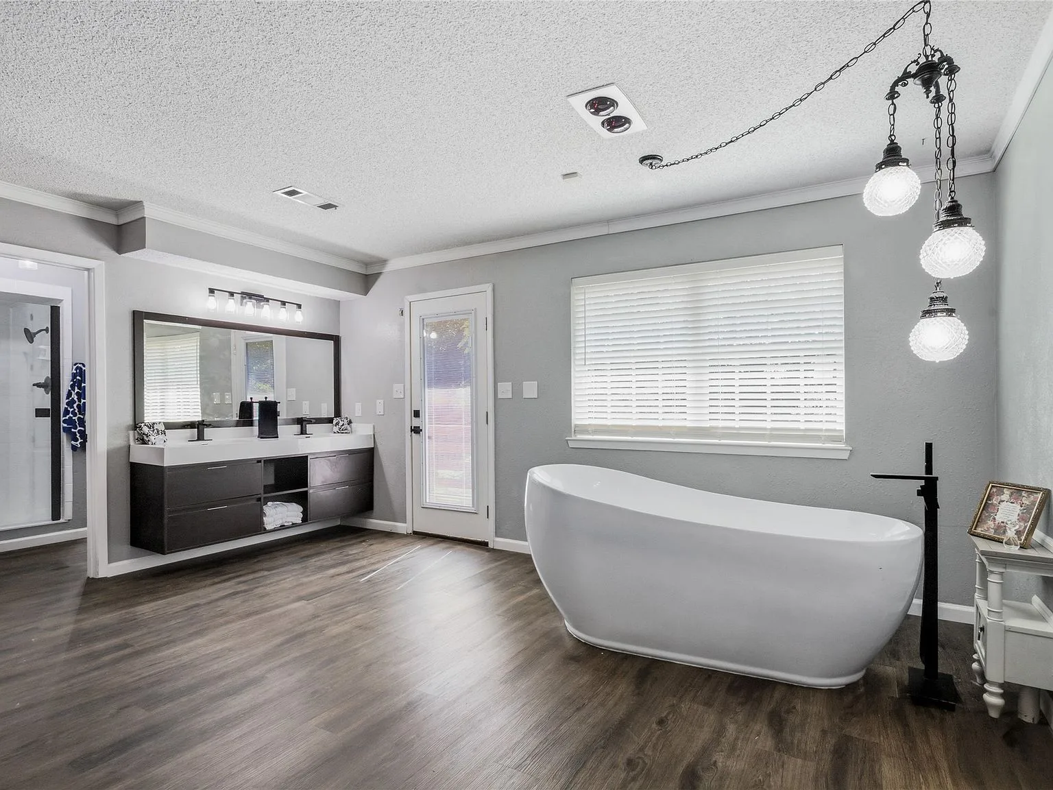 Primary bathroom with freestanding soaking tub, dark floating vanity, and matte black fixtures