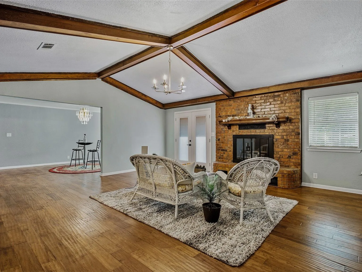 Living room with wood beam vaulted ceiling and exposed brick fireplace