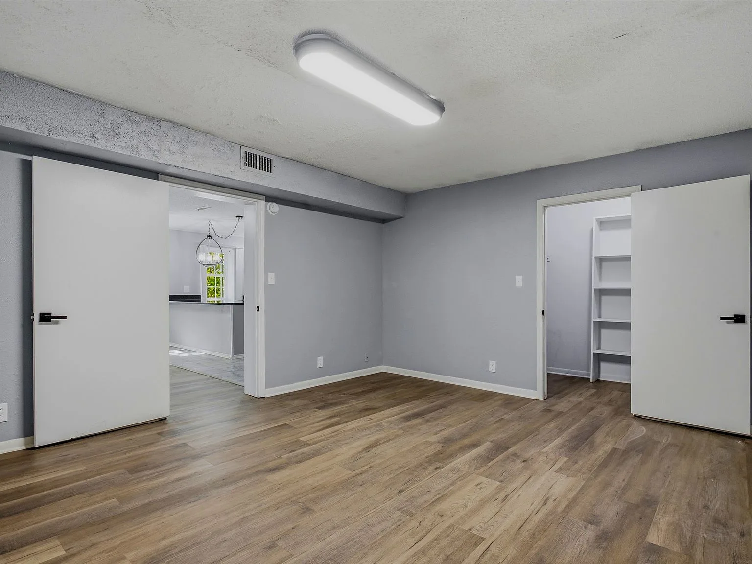 Basement bedroom with grey walls and wood-look laminate flooring
