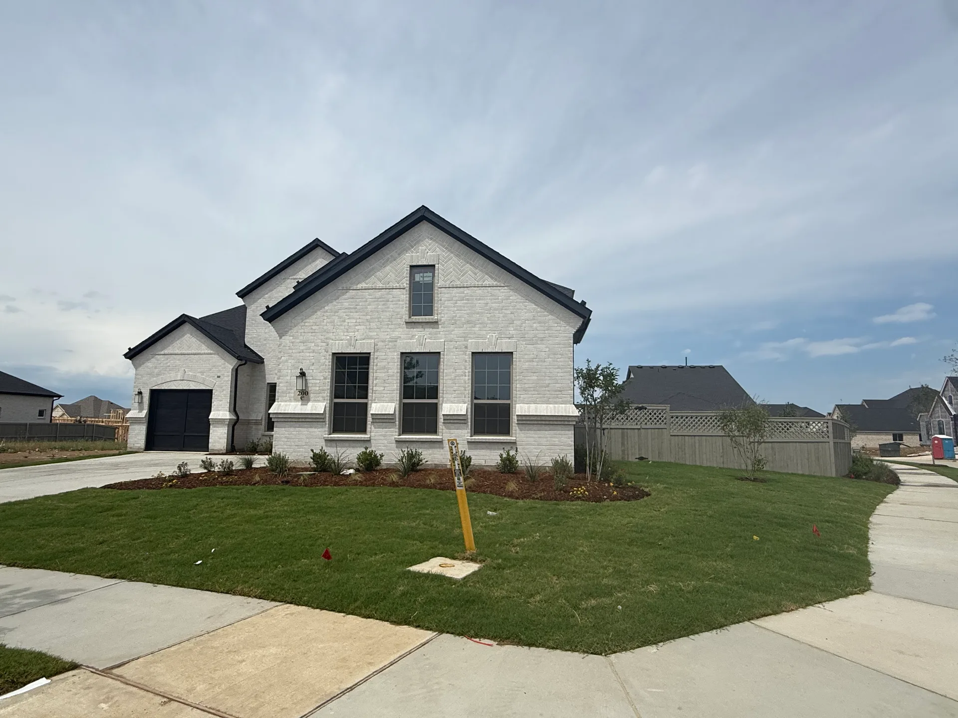 New-construction white-brick home exterior at Furst Ranch in the Flower Mound–Argyle area of Texas