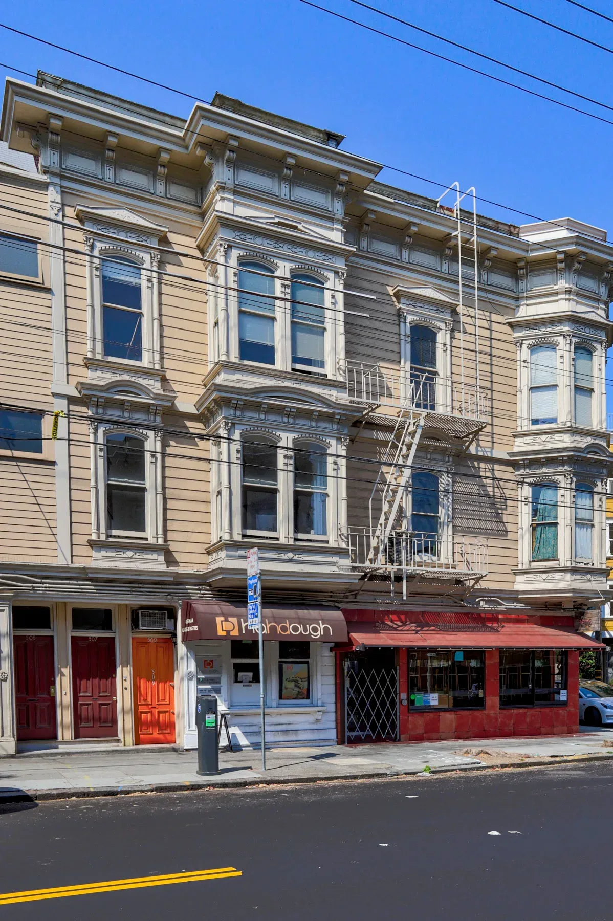 Ornate 1885 Victorian facade with bay windows and commercial storefronts