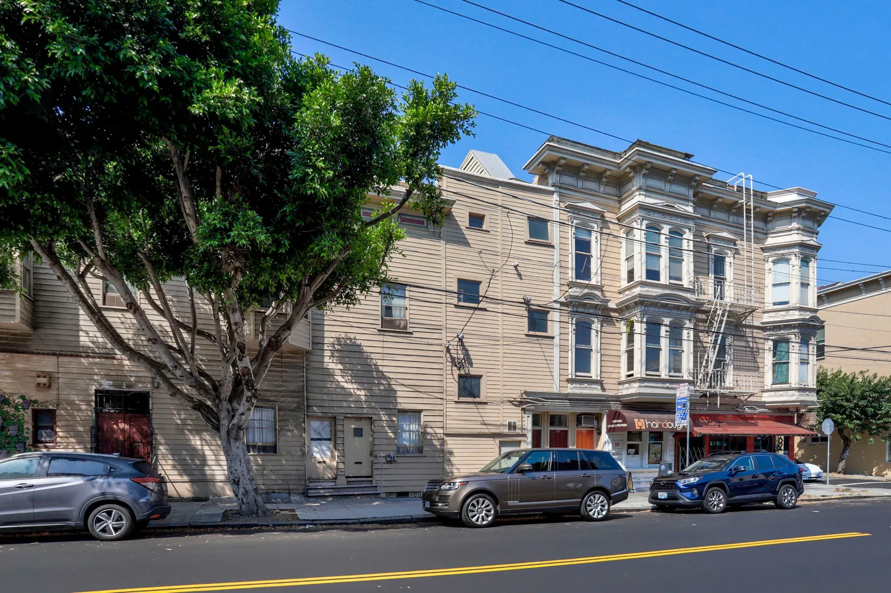 Facade shot showing decorative cornice, bay windows, and fire escape