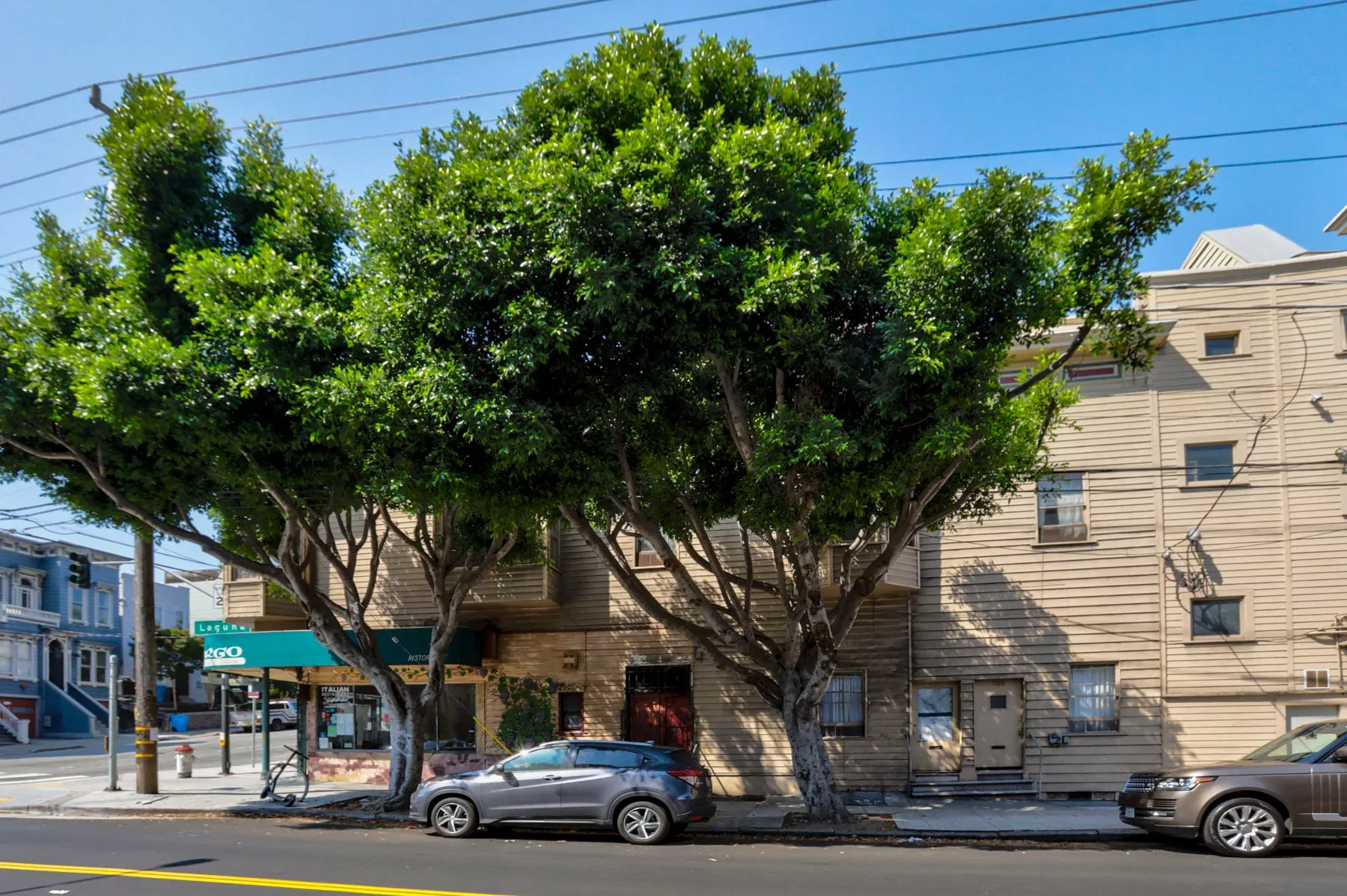Mixed-use complex with green awning and ground-floor commercial storefront
