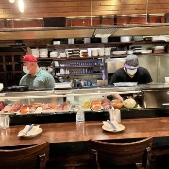 Interior commercial sushi bar with wooden counter and display case