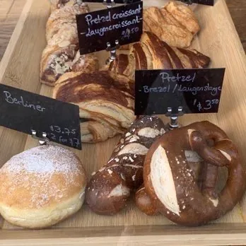 Bakery display case with fresh baked goods including Berliner and croissants