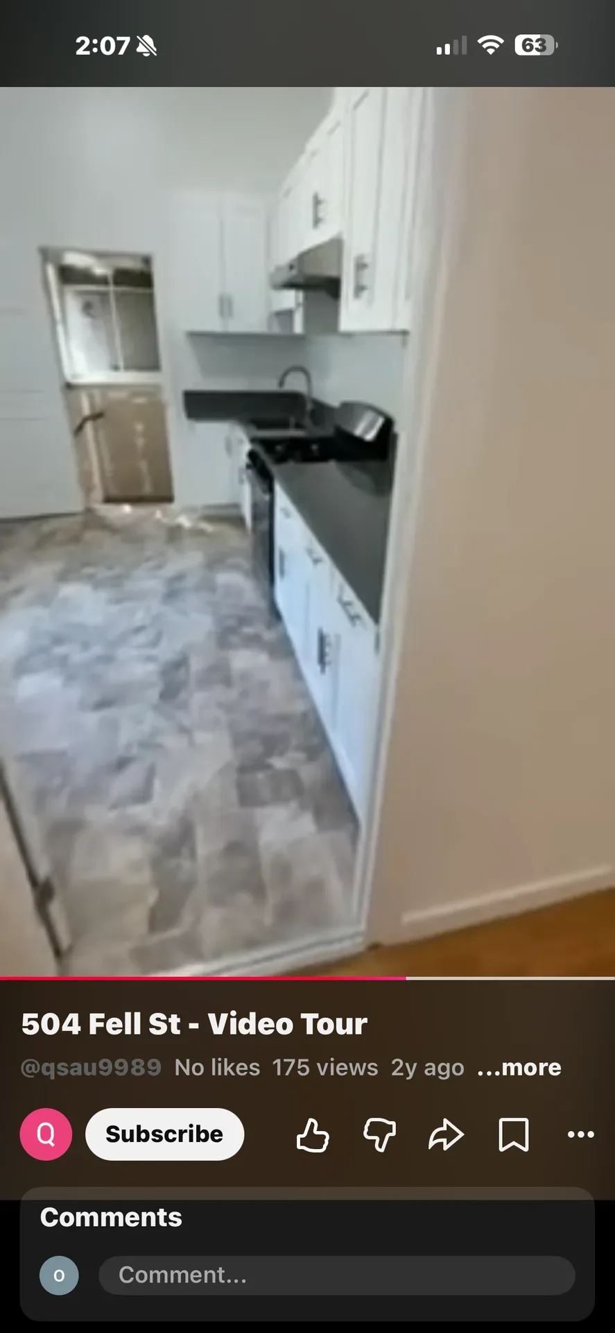Renovated galley kitchen with white shaker cabinetry and dark countertops