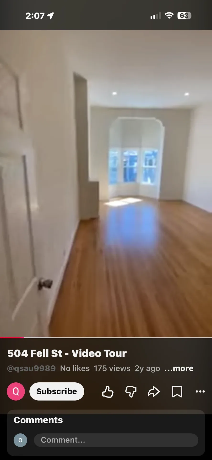 Vacant living room with hardwood floors and arched bay window