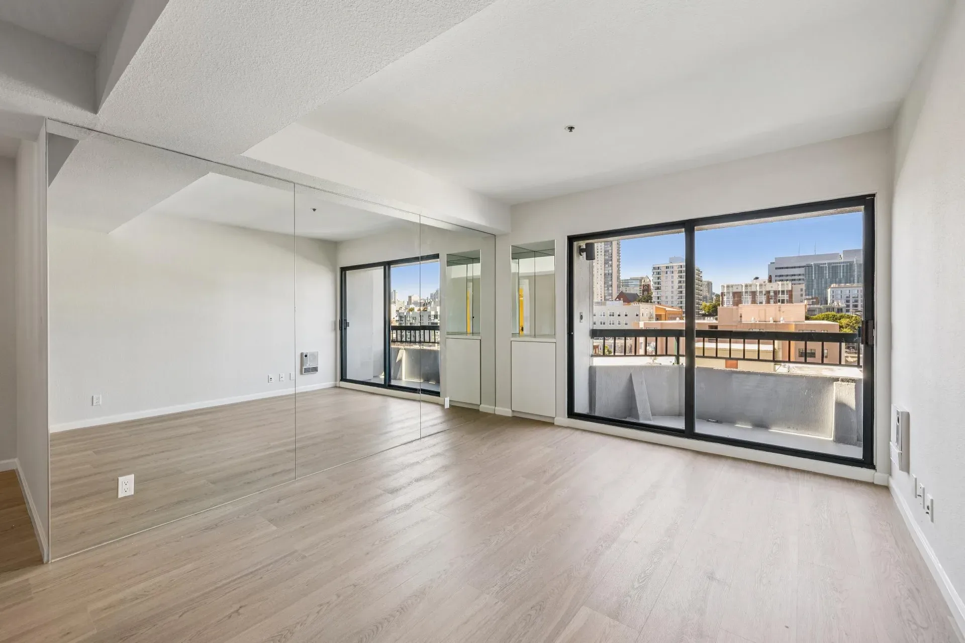 Bedroom with mirrored closet doors and sliding glass door at Opera Plaza