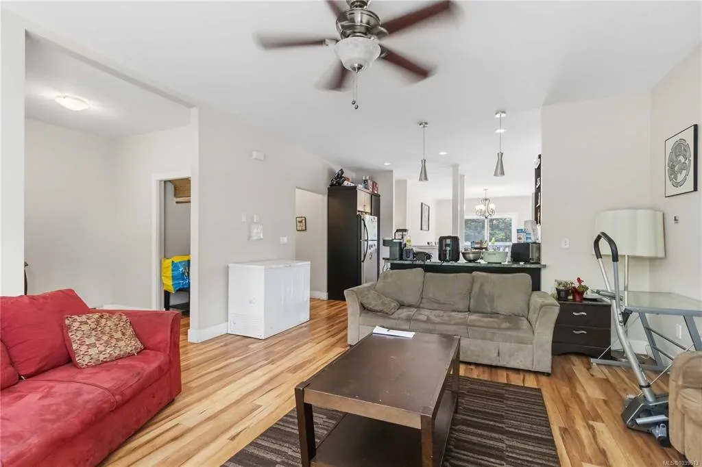 Open-concept living and kitchen area with wood flooring and neutral finishes