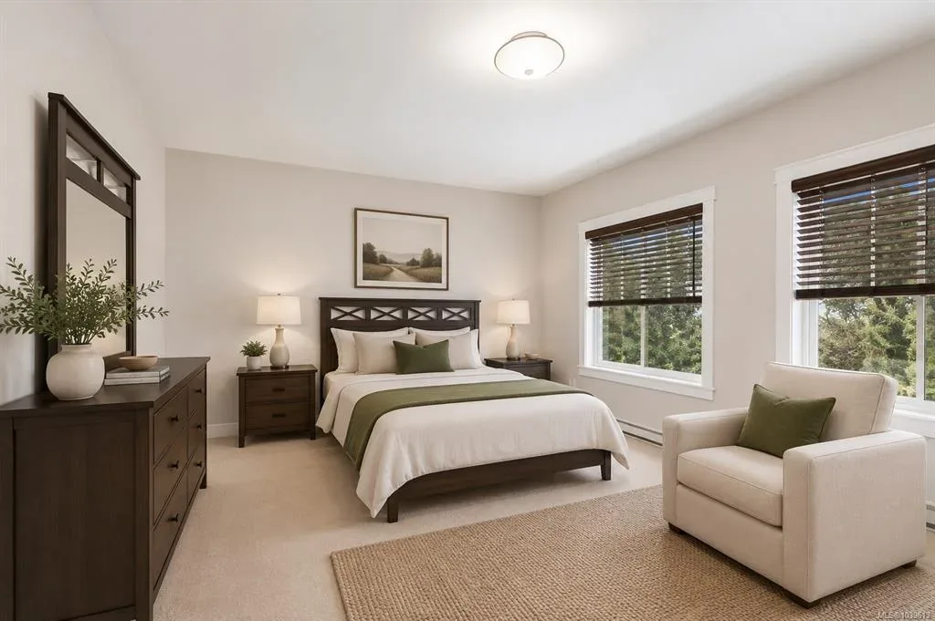 Main-floor primary bedroom with dark wood furniture, multiple windows, and warm neutral tones
