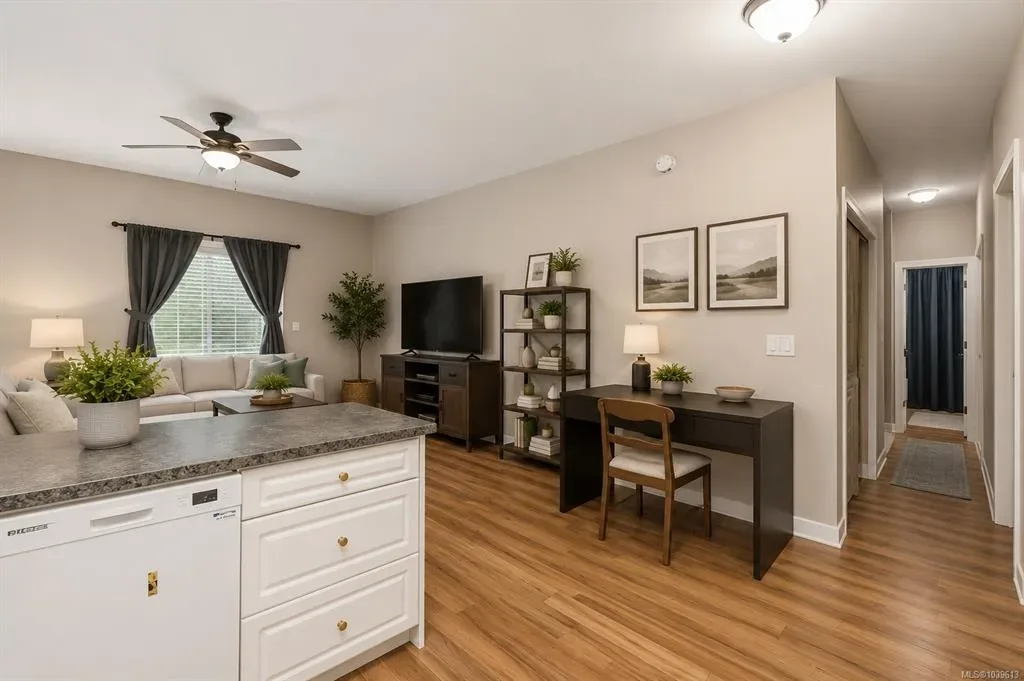 Open-concept living area looking through to the kitchen with white cabinetry