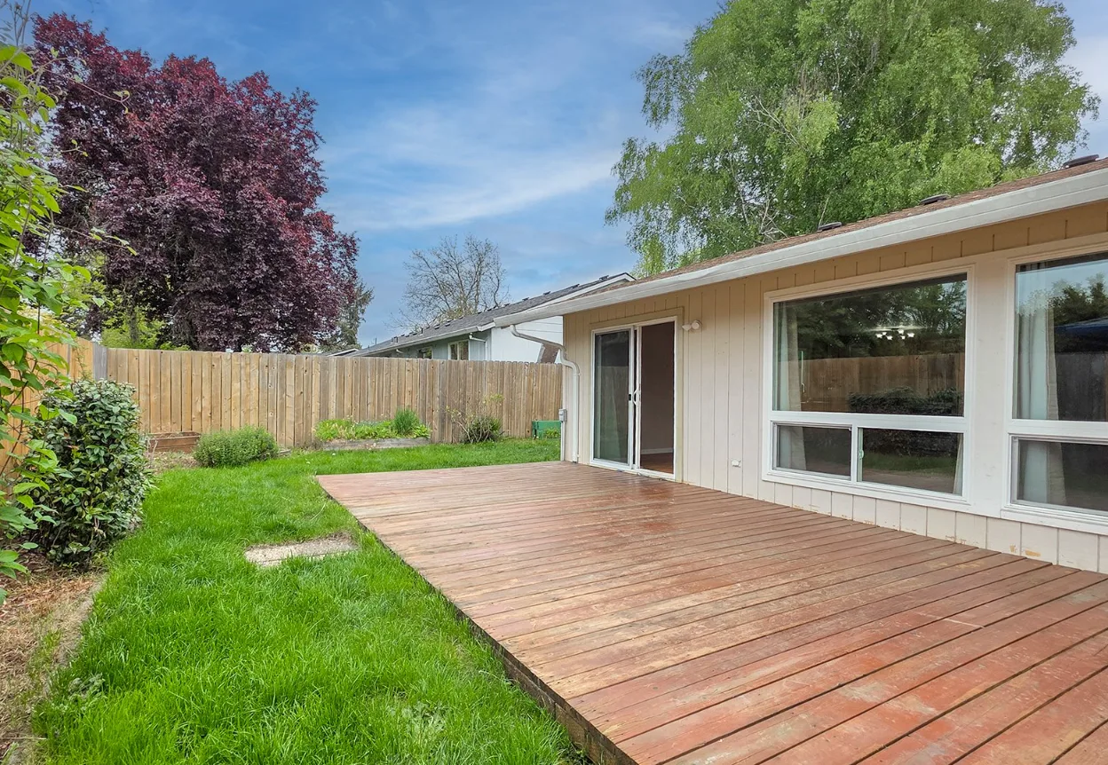 Backyard with large wooden deck and privacy fence