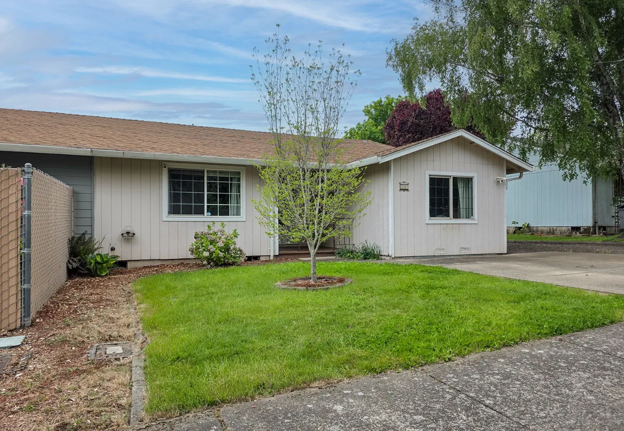 225 SW Fleishauer Ln - exterior front view with light beige siding and brown shingle roof