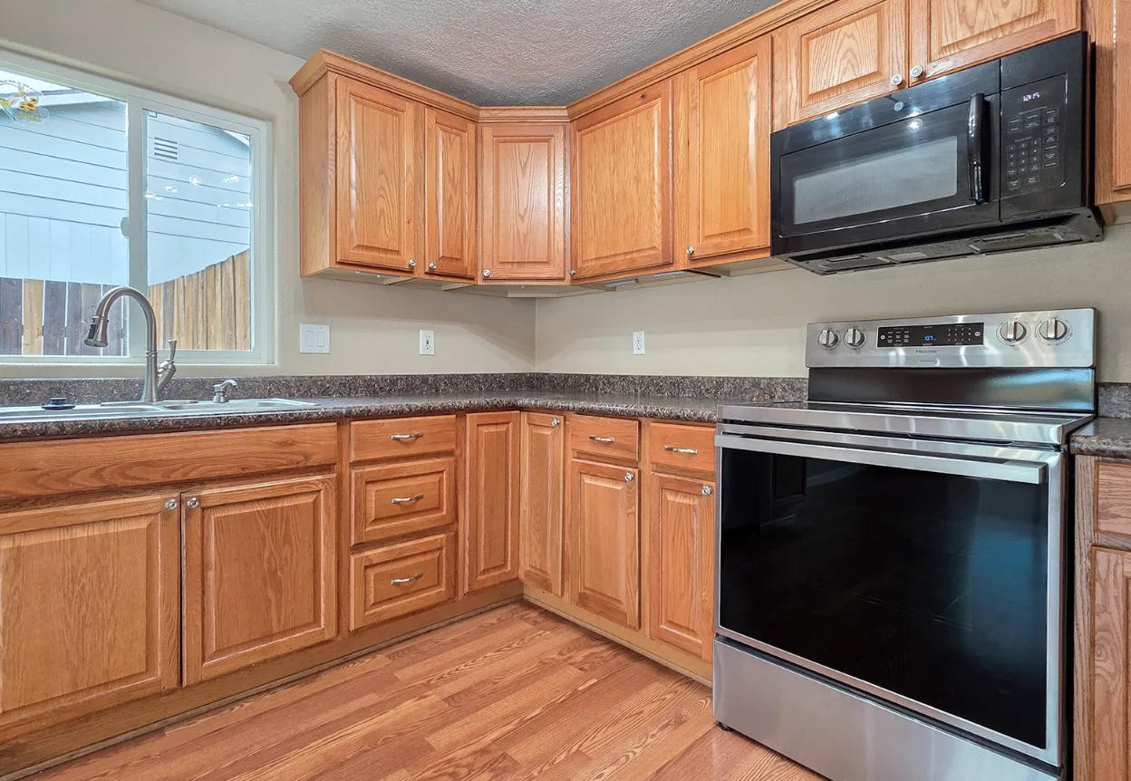 Kitchen second view with oak cabinets and wood-look flooring