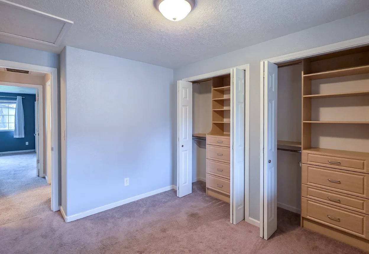 Bedroom with built-in wooden closet organizers